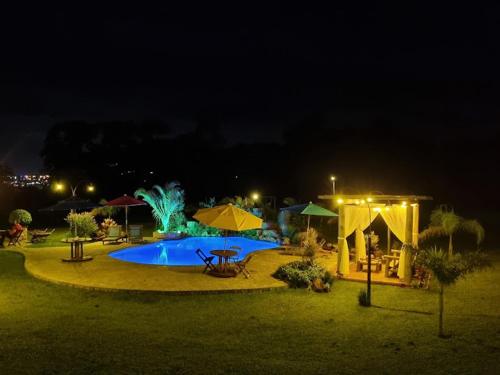 a large swimming pool at night with at Recanto da Natureza in Brotas