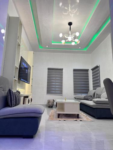 Una sala de estar con luces verdes en el techo. en SG Apartments, en Abuja