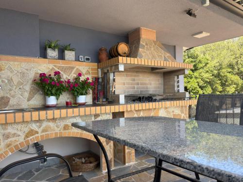 a kitchen with a table and a brick oven at Vjosa Balcony Villa in Tepelenë