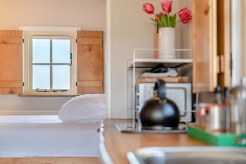 a kitchen with a table and a window with flowers at Maes Shepherds Hut in Uldale