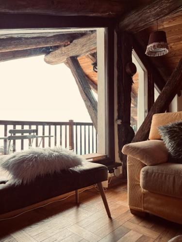 a living room with a couch and a large window at Chalet Lumière Alpine in La Salle