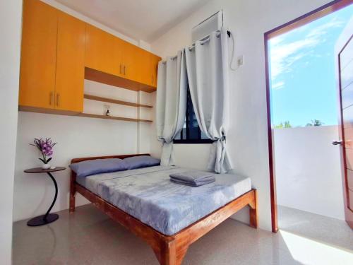 a small bed in a room with a window at Apartelle 386 in Dipolog