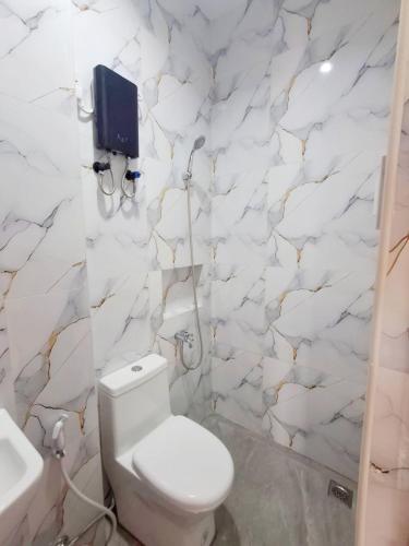 a white bathroom with a toilet and a sink at Apartelle 386 in Dipolog