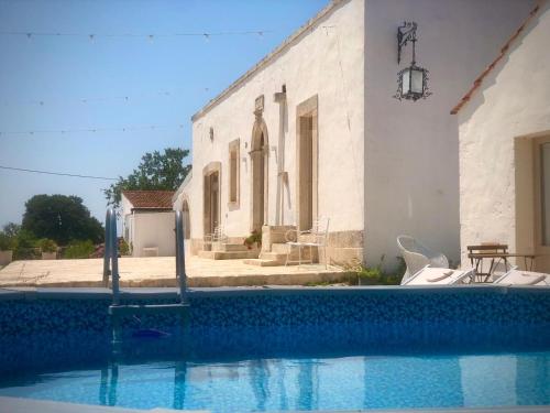 a house with a swimming pool in front of a building at Villa Nuova 1924 in Mottola