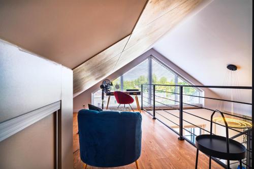 a room with a large window and a blue chair at Morze Apartamentów Apartament West Łeba A20 in Łeba