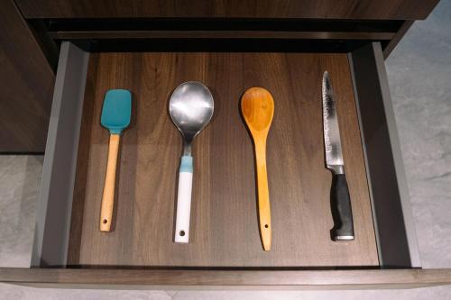 four different utensils in a wooden box at POX - The world of Romero Brito in the Green Tower in Santa Cruz de la Sierra