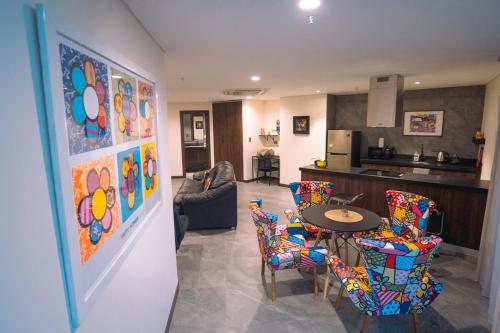 a kitchen and a living room with a table and chairs at POX - The world of Romero Brito in the Green Tower in Santa Cruz de la Sierra