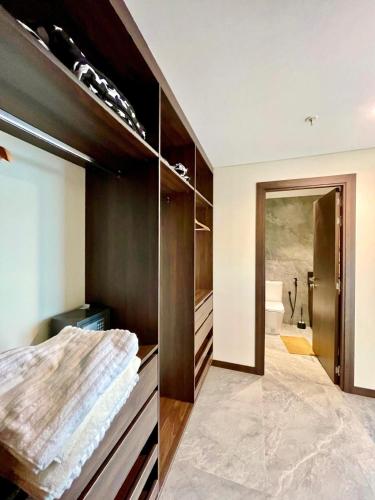 a bathroom with wooden cabinets and a walk in closet at POX - The world of Romero Brito in the Green Tower in Santa Cruz de la Sierra