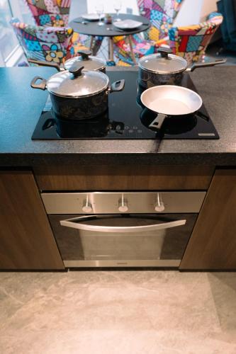 a stove with two pots and pans on top of it at POX - The world of Romero Brito in the Green Tower in Santa Cruz de la Sierra