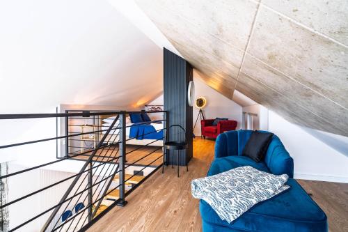 a living room with a staircase and a blue couch at Morze Apartamentów Apartament West Łeba A20 in Łeba