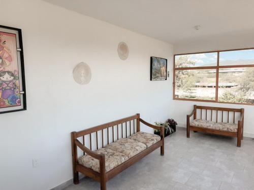 a living room with two benches and a window at Posada Terra Santa in Tequisquiapan