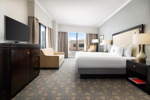 a hotel room with a bed and a flat screen tv at Riverfront Hotel New Orleans in New Orleans