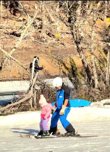 a man and a child on skis in the snow at Habitacion Privada en Casa de Ale in San Martín de los Andes