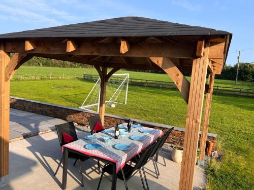 a wooden gazebo with a table and chairs at Beechwood Country House in Killarney