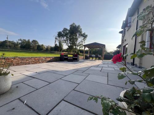 a stone patio with a gazebo next to a building at Beechwood Country House in Killarney
