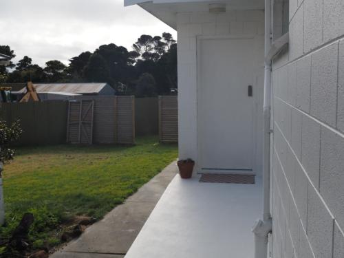a white door on the side of a house at Bastu & backhouse in Bicheno