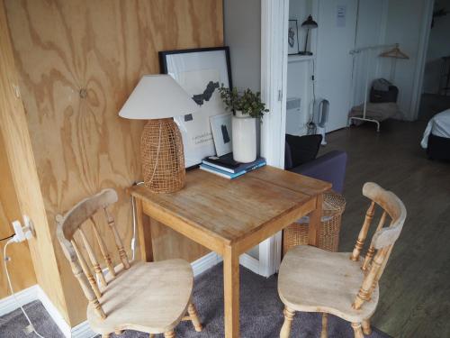 a room with a table with two chairs and a lamp at Bastu & backhouse in Bicheno