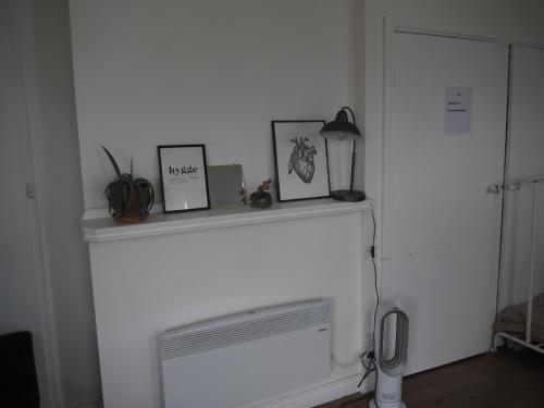 a white fireplace with pictures and a lamp on it at Bastu & backhouse in Bicheno
