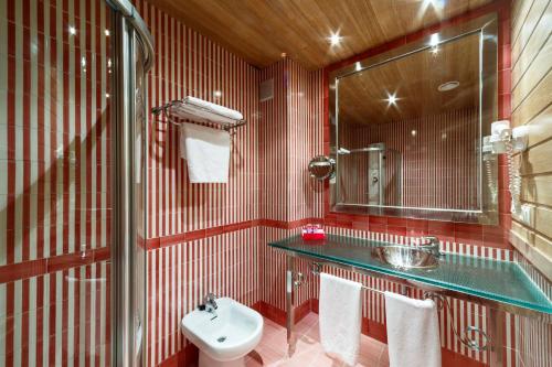 Baño rojo con lavabo y aseo en Hotel Azofra en Burgos