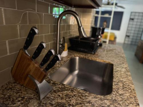 a kitchen counter with a sink and a knife holder at Budget Kingston Classic - Kensington Nest in Kingston
