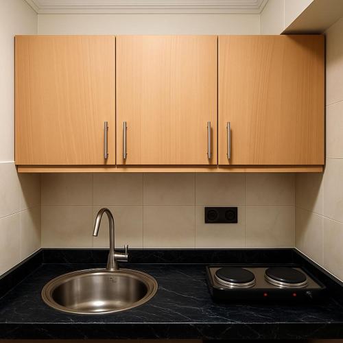 a kitchen with a sink and wooden cabinets at Apparts-hôtel ISNI in Agadir