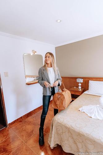 a woman standing in a hotel room with a suitcase at Hotel Ortegal in Mar del Plata