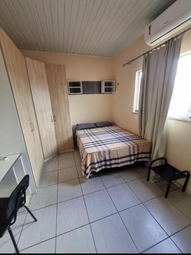 a bedroom with a bed and a desk in it at Suíte Confortável 2 in Belém
