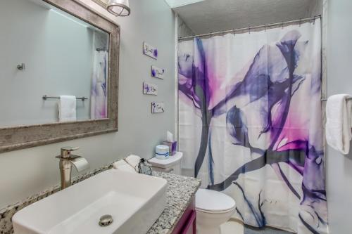 a bathroom with a white sink and a purple shower curtain at Charming Myrtle Beach Townhome Walk to Beach in Myrtle Beach