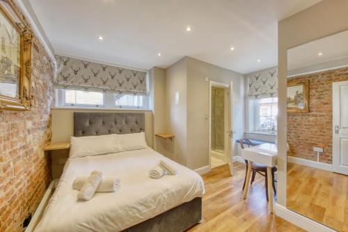 a bedroom with a bed and a brick wall at The Foresters Arms in Kingston upon Thames