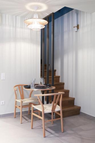 a dining room with a table and chairs and a chandelier at Maistros Deluxe Apartments in Ierissos