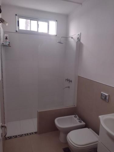 a bathroom with a toilet and a shower and a sink at Casa céntrica con piscina in Paraná