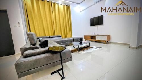 Una sala de estar con un sofá y un televisor. en Mahanaim Luxury apartments, en Lusaka