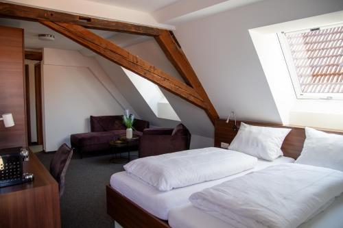 a bedroom with a bed and a living room at Hotel Zum Bären in Münnerstadt