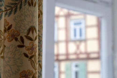 a window with a curtain in front of a building at Hotel Zum Bären in Münnerstadt