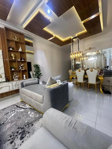 a living room with a couch and a dining room at Kayla Golden Muse in Lagos