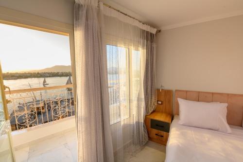 a bedroom with a bed and a large window at Rhapsody of Luxor in Luxor