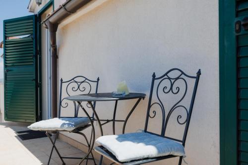 a table and two chairs sitting on a balcony at Karantanovi Dvori in Murter