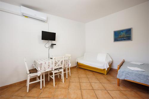 a room with a bed and a table and chairs at Karantanovi Dvori in Murter