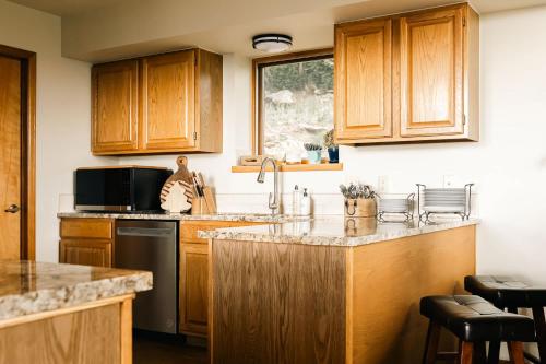 a kitchen with wooden cabinets and a counter top at Serene Rocky MTN Retreat w Hot Tub - Pet-Friendly in Evergreen