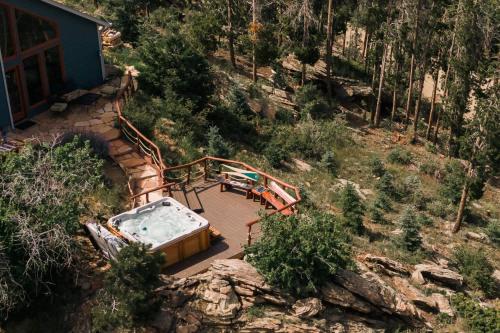 a bath tub sitting on a deck next to a house at Serene Rocky MTN Retreat w Hot Tub - Pet-Friendly in Evergreen