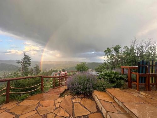 a rainbow in the sky over a mountain at Serene Rocky MTN Retreat w Hot Tub - Pet-Friendly in Evergreen