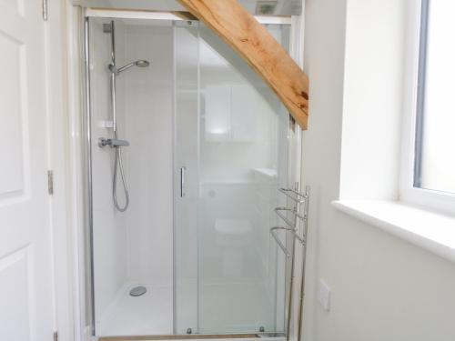 a shower with a glass door in a bathroom at Roman Lodge in Weymouth