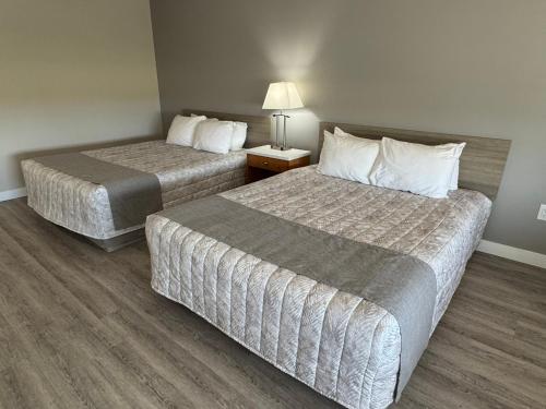 a hotel room with two beds and a lamp at Western Budget Motel Leduc #3 in Leduc
