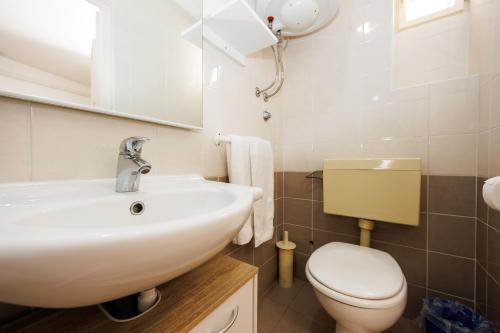 a bathroom with a white sink and a toilet at Karantanovi Dvori in Murter