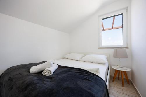 a white bedroom with a bed and a window at Karantanovi Dvori in Murter