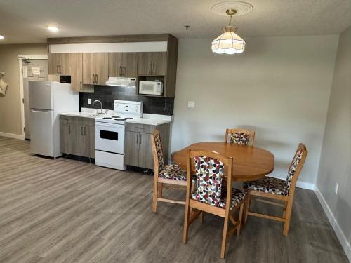 a kitchen with a table and chairs and a refrigerator at Western Budget Motel Leduc #3 in Leduc