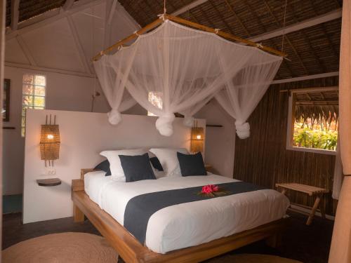 a bedroom with a large bed with a flower on it at Dicilaba Lodge in Sainte Marie