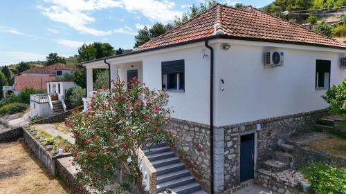 a small white house with a tree in front of it at Villa Balani in Široka