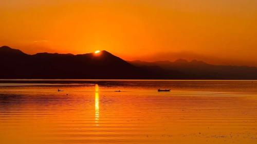 a sunset over a body of water with a mountain at Villa Balani in Široka