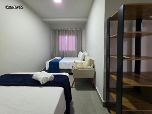 a hotel room with two beds and a chair at Casa com 2 quartos na Vila A prox Paraguai e Itaip in Foz do Iguaçu